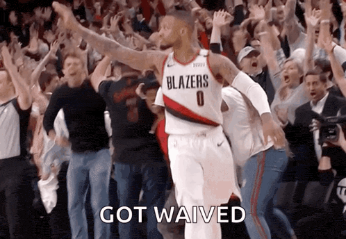 a basketball player in a blazers jersey celebrates with the crowd