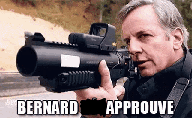 a man is holding a gun with the words bernard approve written on it .
