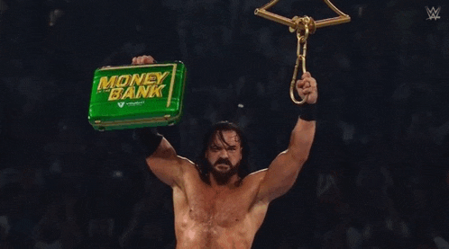 a wrestler holds up a money bank briefcase