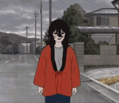 a person wearing a red jacket is standing on a street in front of a house