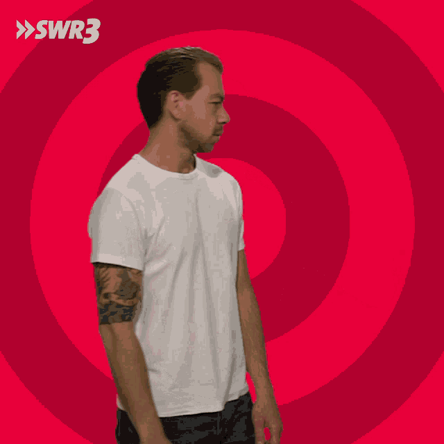 a man in a white t-shirt stands in front of a red circle with swr3 written on it