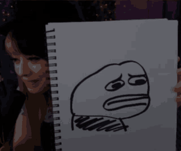 a woman is holding a drawing of a face that says ' i 'm sorry ' on it