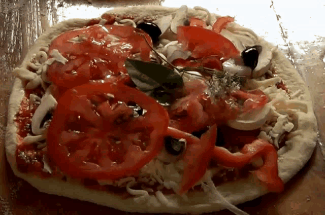 a pizza with tomatoes and olives on top