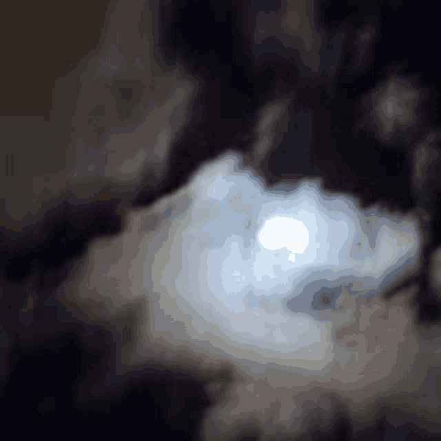 a full moon is shining through the clouds in the night sky