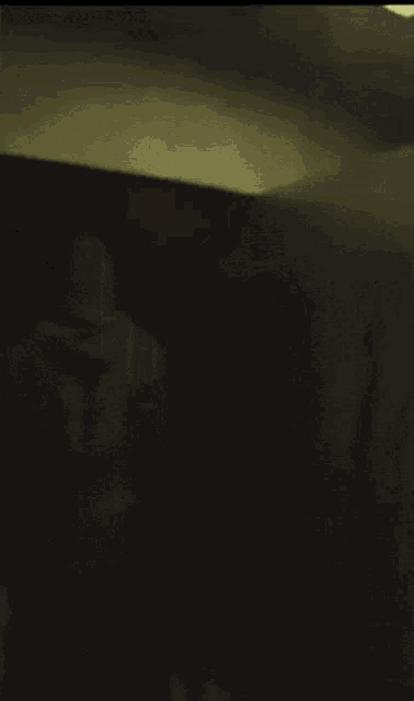 a dark room with a door that is open and a shadow on the wall