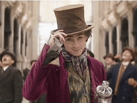 a man in a purple suit and top hat is holding a jar of chocolate .