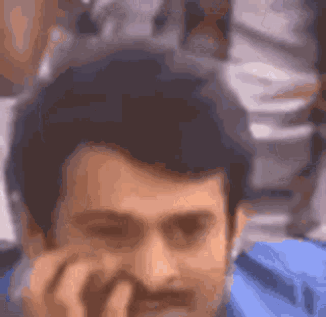 a man with a beard is talking on a cell phone and smiling .