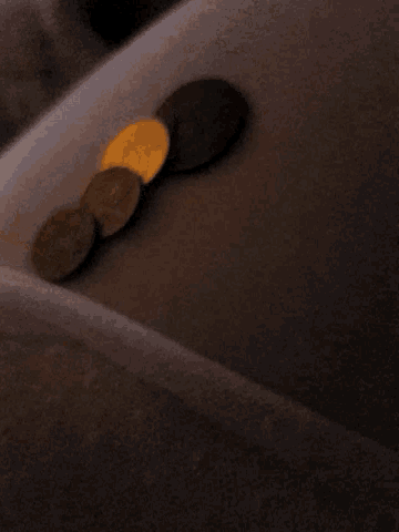 a blurred image of a person 's arm with a few coins on it