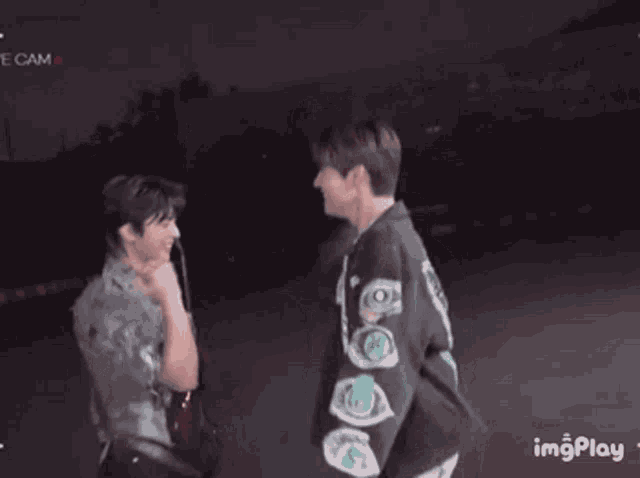 a couple of men are standing next to each other on a stage .