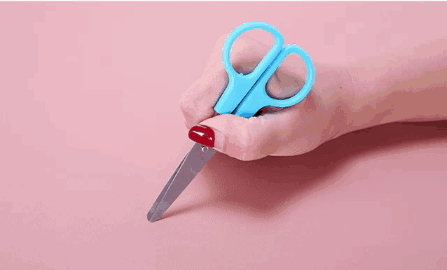 a person holding a pair of blue scissors