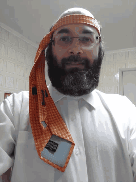 a man with a beard and glasses wearing an orange tie on his head