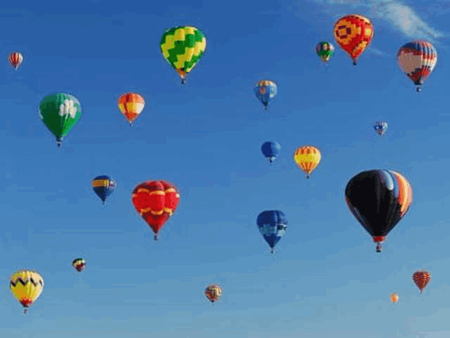 a bunch of hot air balloons flying in the sky