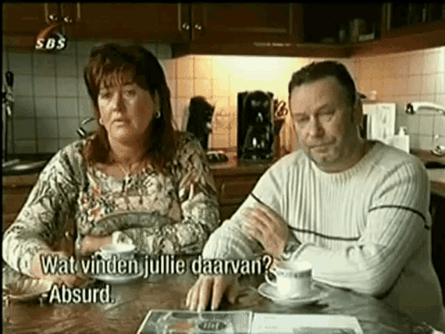 a man and a woman are sitting at a table in a kitchen with sbs written on the bottom of the screen