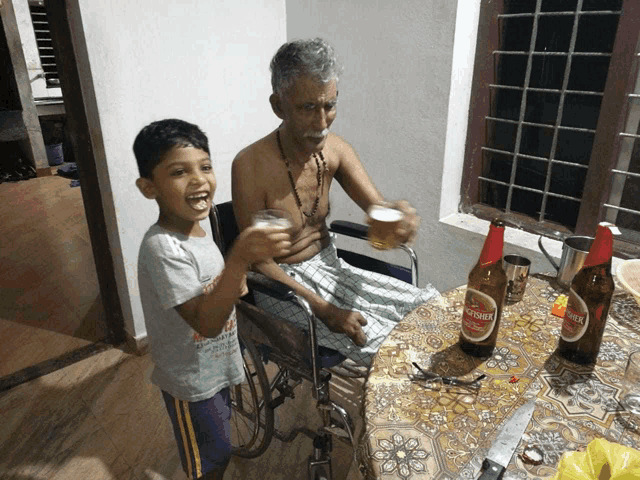 a man in a wheelchair is sitting at a table holding a glass of beer