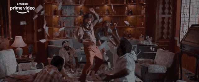 a group of men are dancing in a living room with an amazon prime video logo