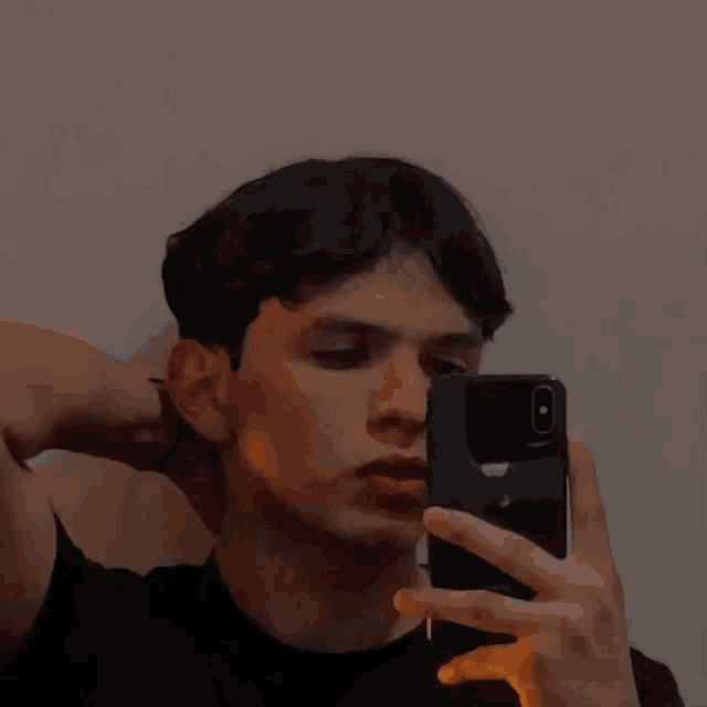 a young man taking a selfie with his iphone