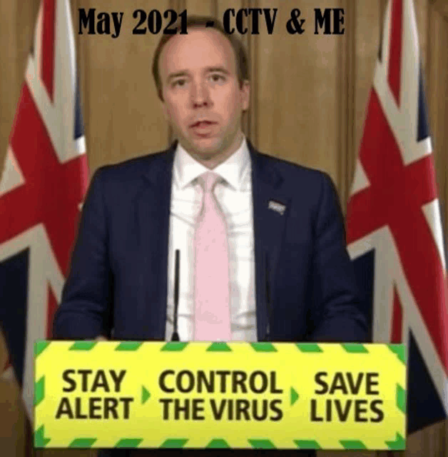 a man in a suit and tie is standing behind a podium with a sign that says stay alert control the virus save lives .