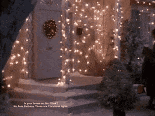 a house is decorated with christmas lights and a wreath on the front door