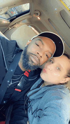 a man and a woman are taking a selfie in a car