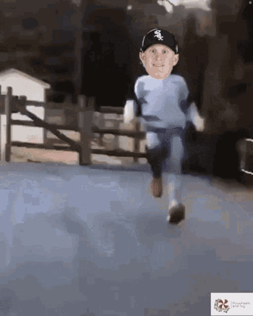 a little boy wearing a white sox hat is running