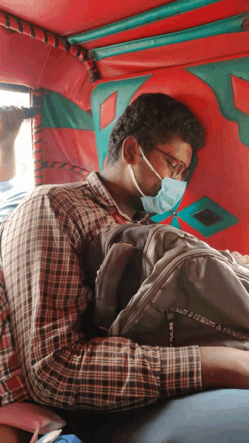 a man wearing a mask and glasses is sleeping on a red couch