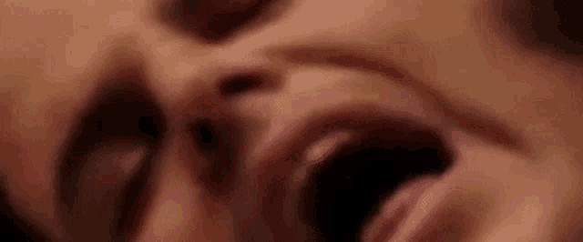 a close up of a woman 's face with her mouth wide open .