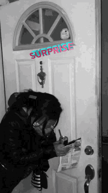 a woman is standing in front of a door with surprise written on it