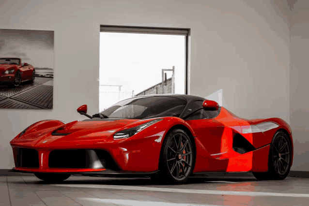 a red sports car is parked in front of a window in a showroom