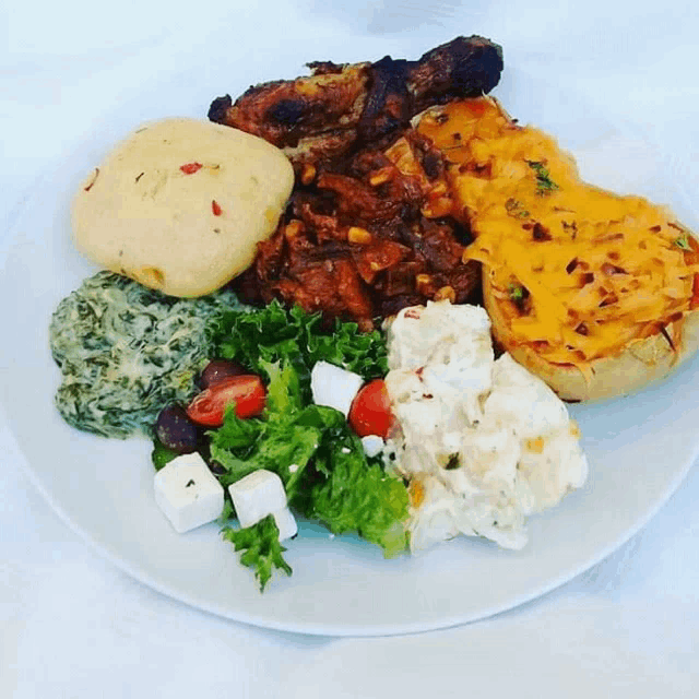 a white plate topped with a variety of food including a salad