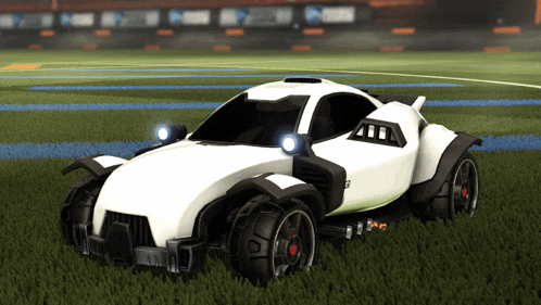 a white car with black wheels is parked on the grass