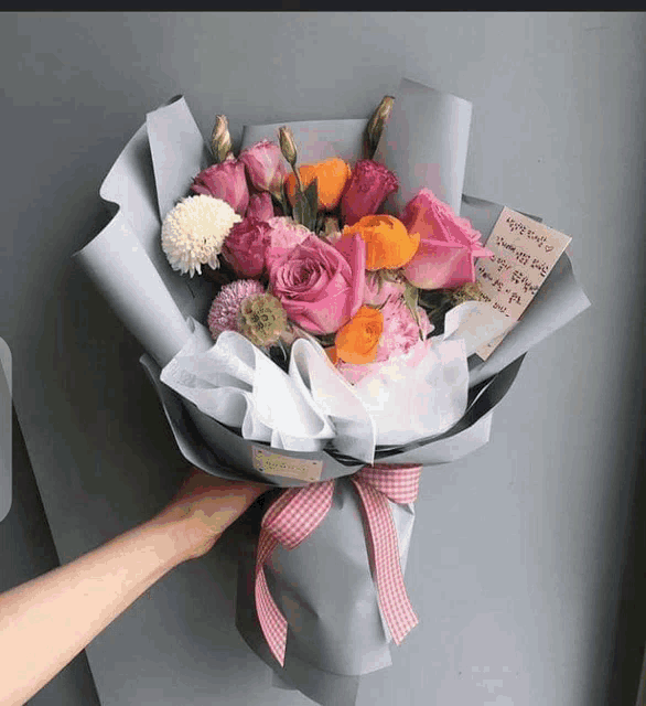 a person is holding a bouquet of flowers with a note on it that says " i love you "