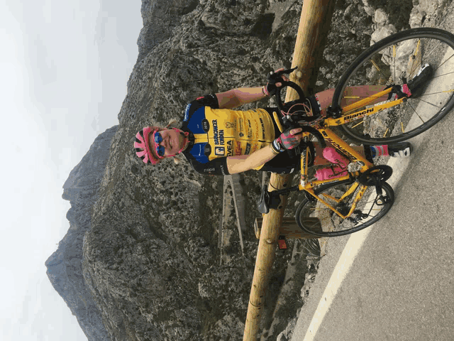 a cyclist wearing a yellow jersey that says ' triumph ' on it