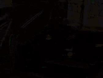 a man with a beard is driving a green car with a helmet on .