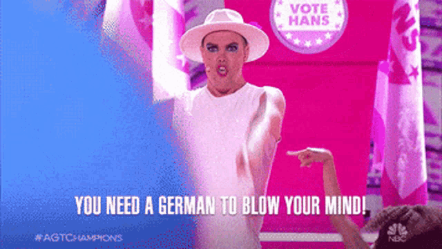 a man in a white hat stands in front of a pink sign that says vote hans