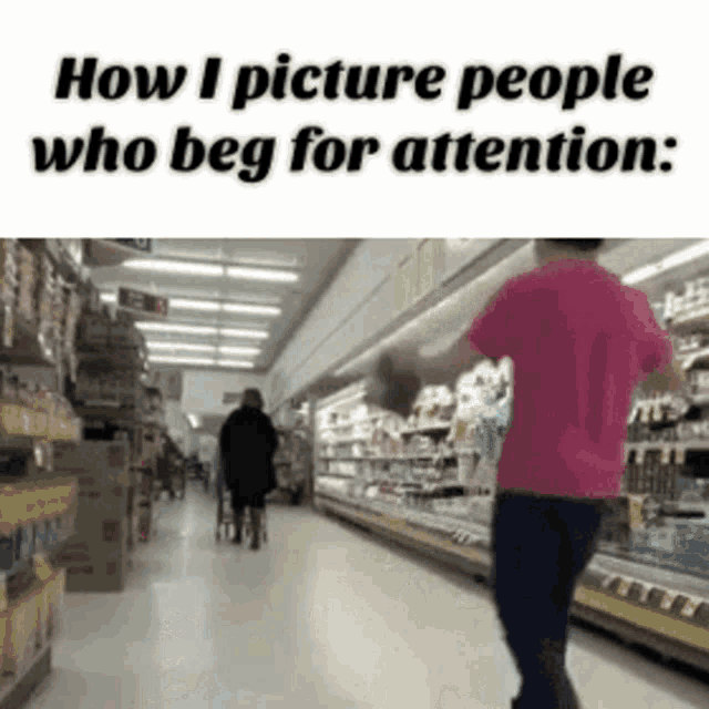 a man in a pink shirt is walking down a grocery store aisle with a woman in a wheelchair .