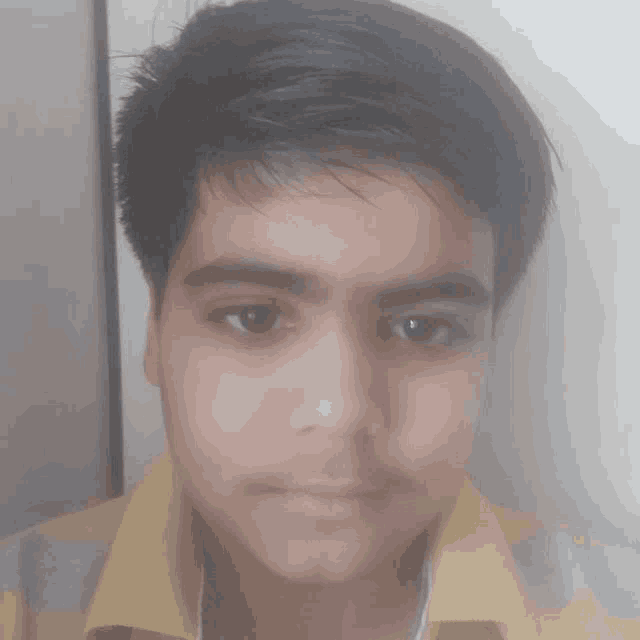 a close up of a boy 's face with a yellow shirt