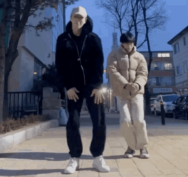 a man and a woman are dancing on a sidewalk in front of a building with a sign that says ' korean '