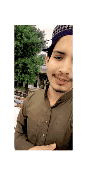 a man wearing a green shirt and a blue hat smiles for the camera