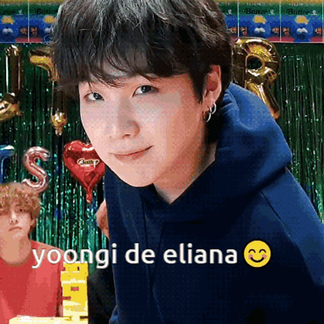 a young man in a blue hoodie with the words yoongi de eliana on the bottom right