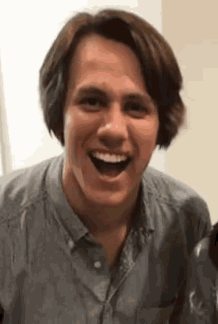 a close up of a man 's face with his mouth open and a smile on his face .