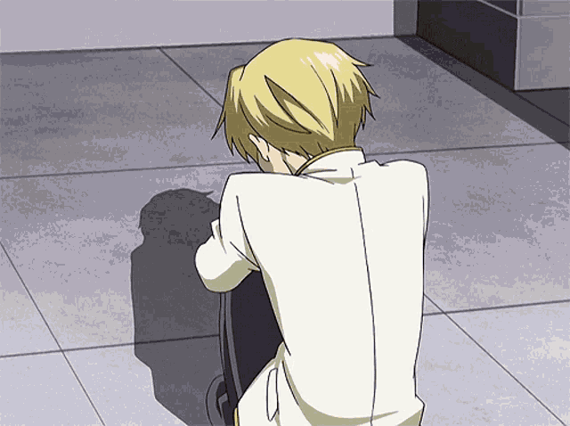 a man with blonde hair is sitting on the floor