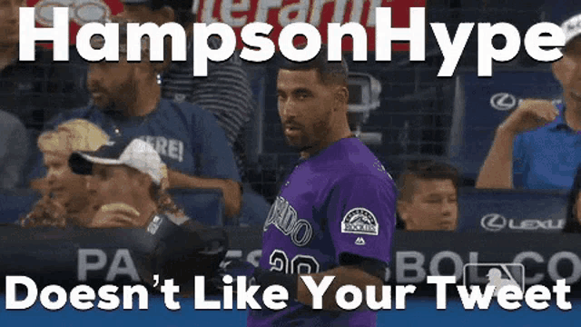 a man in a purple colorado rockies jersey is standing in front of a crowd .