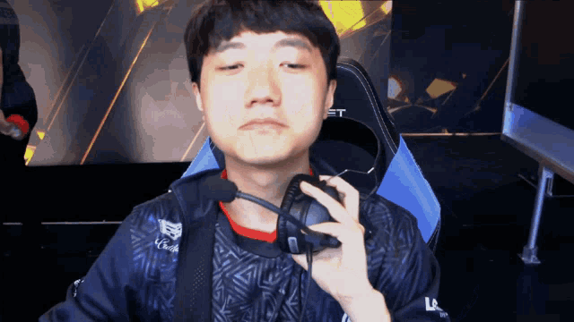 a man wearing headphones with the letter t on the back of his jacket