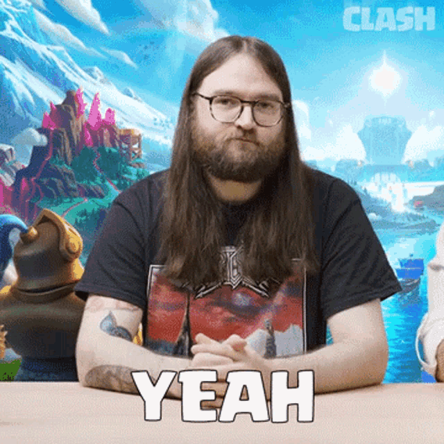 a man with long hair and a beard is sitting at a table with the word yeah in front of him