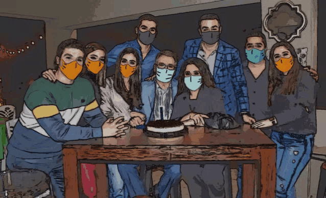 a group of people wearing face masks gather around a table with a cake