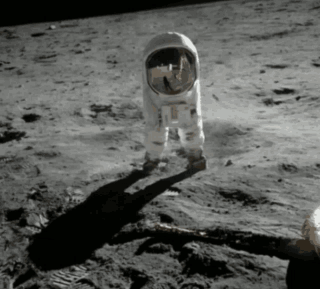 a man in an astronaut 's suit is standing on the moon