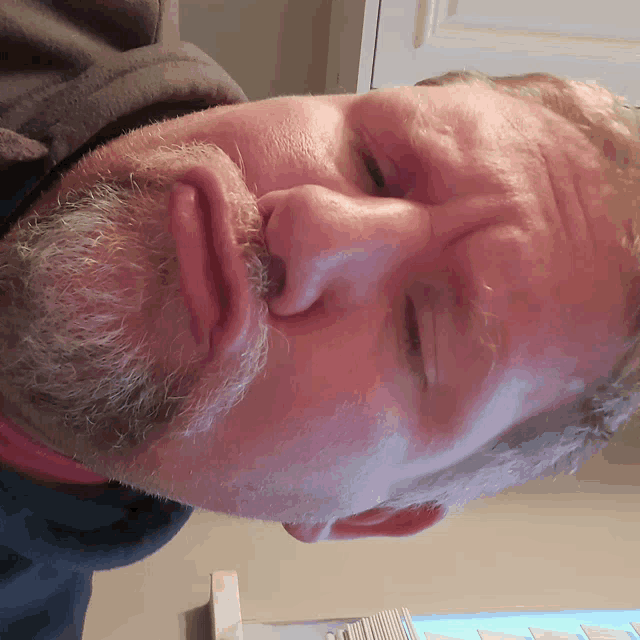 a man with a beard looks down at something