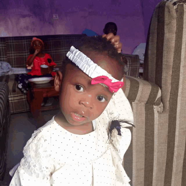 a little girl with a headband on her head