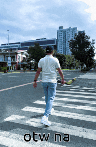 a man walking across a street with the word otw na written on the bottom