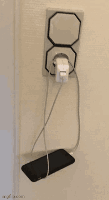 a cell phone is plugged into a charger in a wall outlet